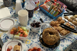 Hier sieht man einen Tisch mit verschiedenen Gerichten wie Kuchen, Obst, etc. für ein Frühstück. 