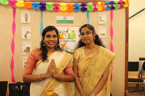 Zwei Inderinnen stehen in traditioneller Kleidung vor einer dekorierten Ausstellerwand