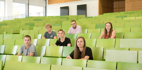 A group of students in lecture hall Students are sitting in a lecture hall.
