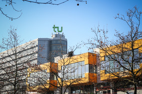 The cafeteria and the math tower with the logo of TU Dortmund University on top and blue sky in the background