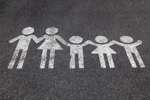 Eine weiße Kreidezeichnung von einer Familie auf dem Boden.